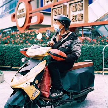 一个戴头盔的男子骑着一辆摩托车在街上行驶。