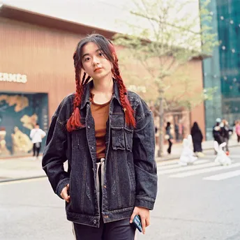 一个红头发的年轻女子站在滑板车上在街上