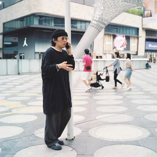 一个人站在一栋建筑前打电话