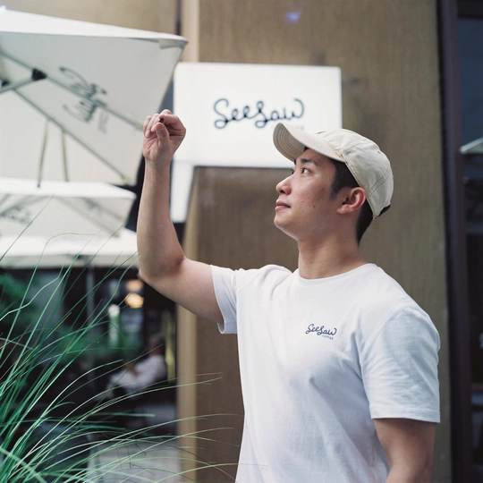 一个戴白帽子的年轻人拿着植物