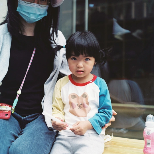 戴面具的女人抱着一个小孩子