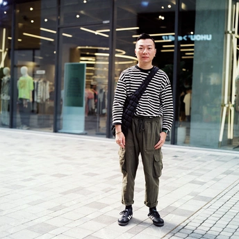 站在街上一栋楼前面的年轻人