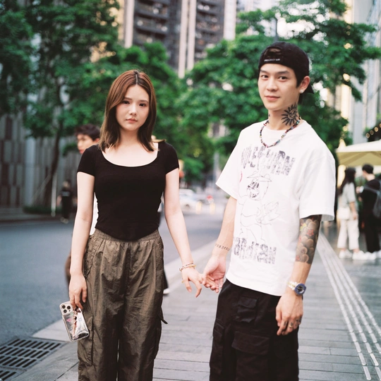 一个小男孩和一个女人手牵手在城市的街道上走