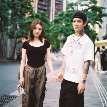 一个小男孩和一个女人手牵手在城市的街道上走