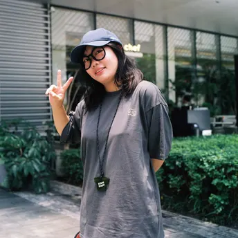 一个戴帽子的年轻女子站在滑板上在街上