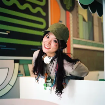 一位年轻女子戴着绿帽子坐在桌子旁