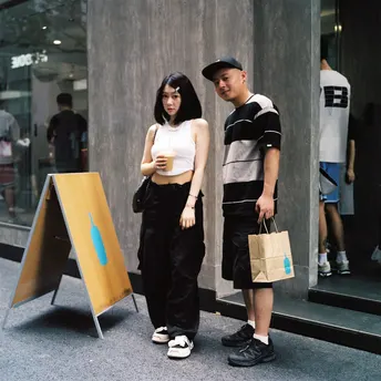 一名年轻男子和一名年轻女子站在人行道上 一名女孩经过。