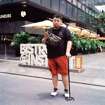 一个男子骑着滑板在街上拿着雨伞