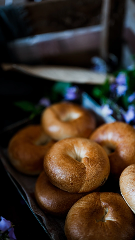 桌子上的托盘上放着几个甜甜圈和一些百吉饼