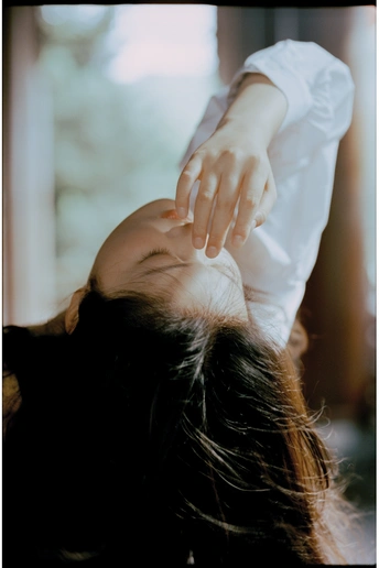 一位年轻女子低着头 用手捂着脸