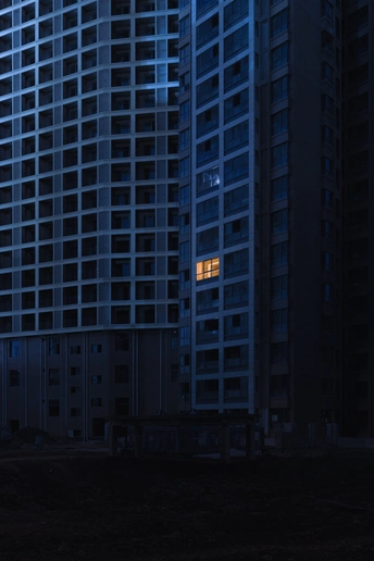 城市夜晚的一栋高楼 月亮在黑暗的天空中。