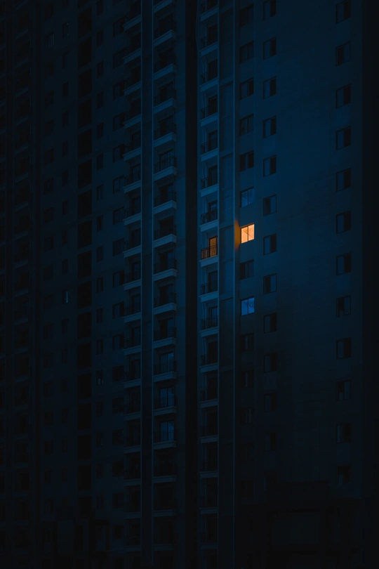 夜晚的黑暗城市 一座带蓝色窗户的高楼