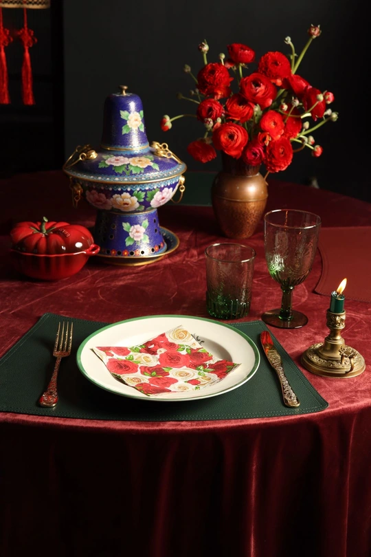 一张为两人准备的桌子 配有披萨、蜡烛和一束红色的玫瑰花。