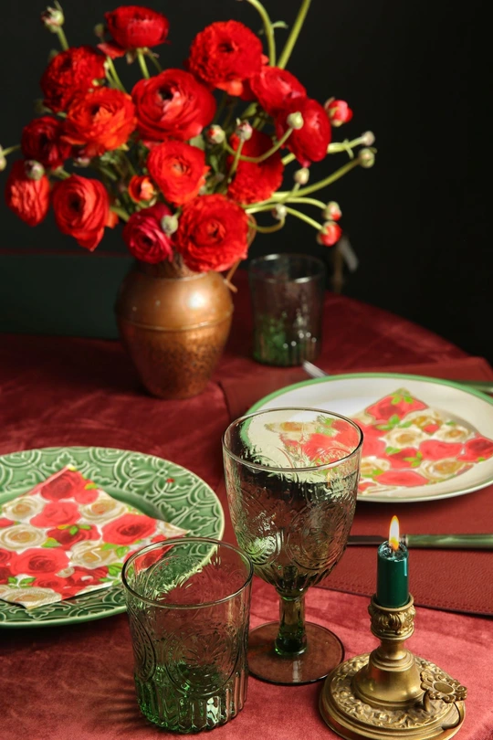 绿色盘子 蜡烛和一束红花的桌子