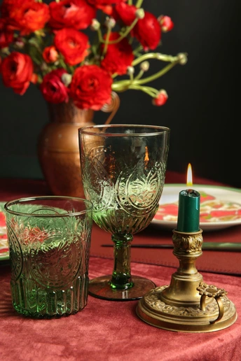 一束红玫瑰和一支蜡烛在一个花瓶里