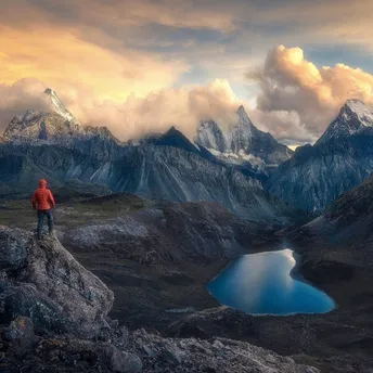 一个人站在山谷里 注视着山中的湖泊。