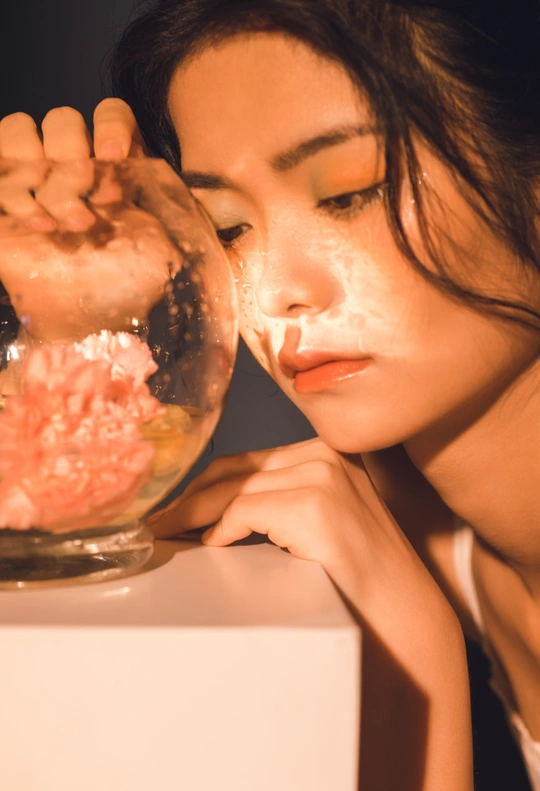 一个年轻女人的脸浸在一碗液体里