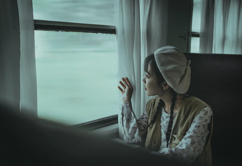 一个年轻女子独自坐在火车上 望着窗外。