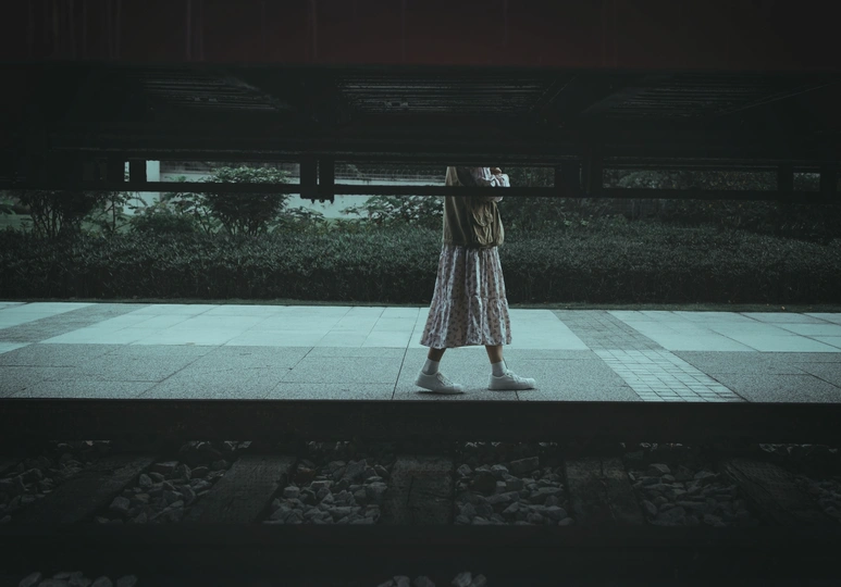 一个穿着连衣裙的女人站在一个黑暗的夜晚在伞下