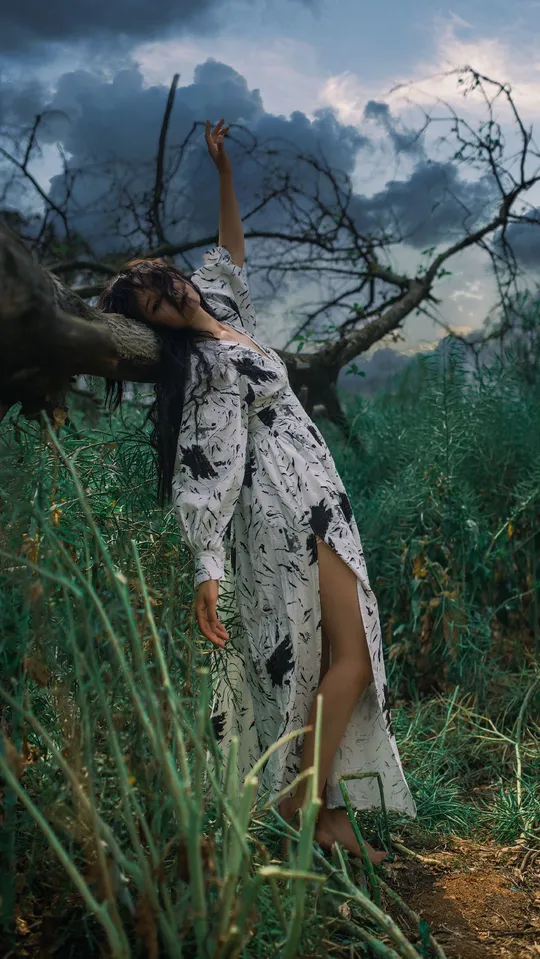 一位穿着长裙的美女站在草地上