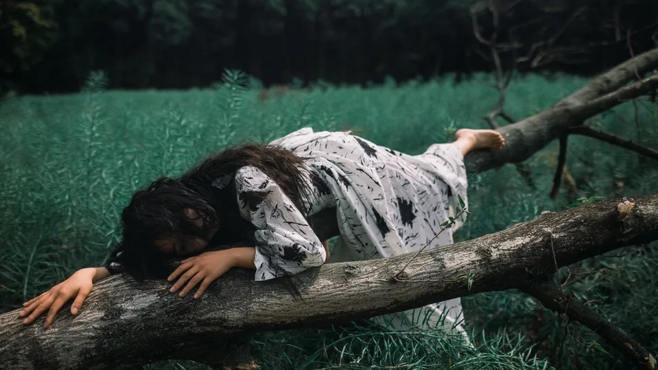 一位年轻女子躺在森林中的一片树枝上