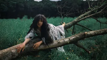 一位女孩在森林中的树枝上