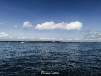 远处的岛屿上空有蓝天白云