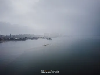 天空中有云和水体 远处有城市。