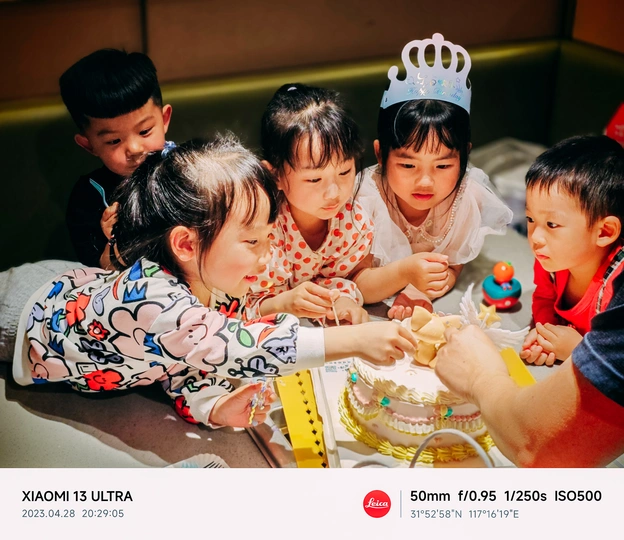 一张孩子在生日派对上切小蛋糕的照片