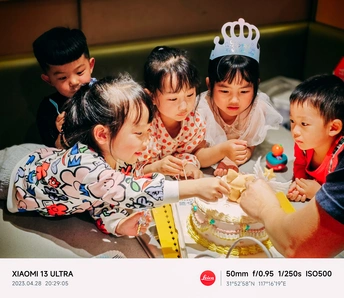 一张孩子在生日派对上切小蛋糕的照片