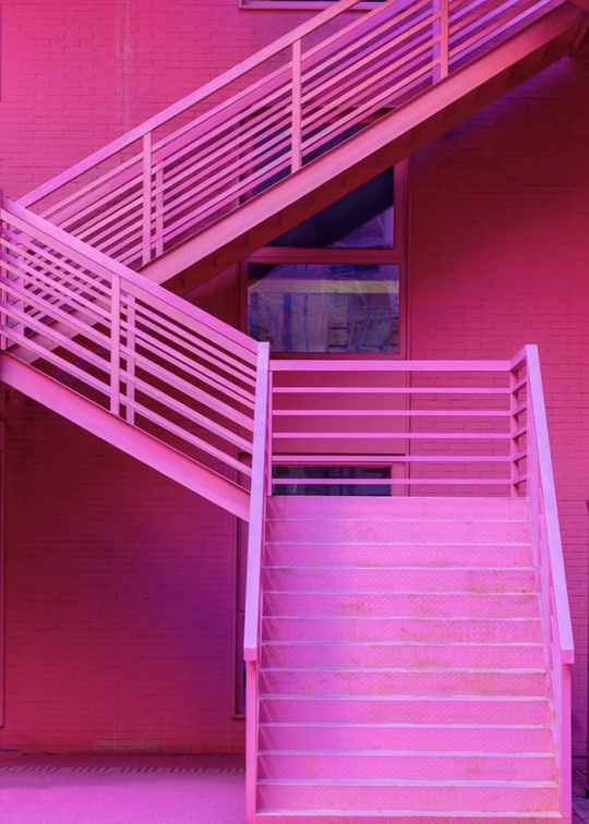有紫色楼梯和台阶的粉红色建筑