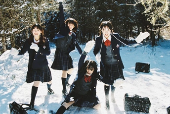 穿制服的年轻女孩站在雪中