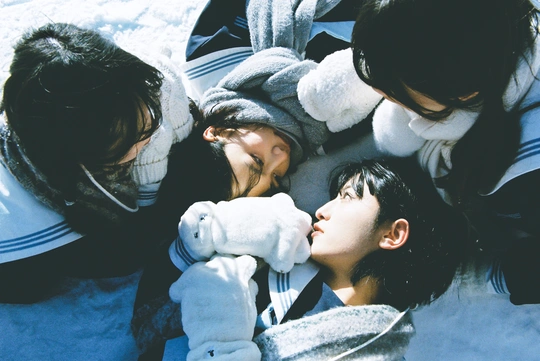 几个年轻人抱着泰迪熊在雪地里 一个女子亲吻一个男孩。