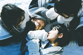 几个年轻人抱着泰迪熊在雪地里 一个女子亲吻一个男孩。