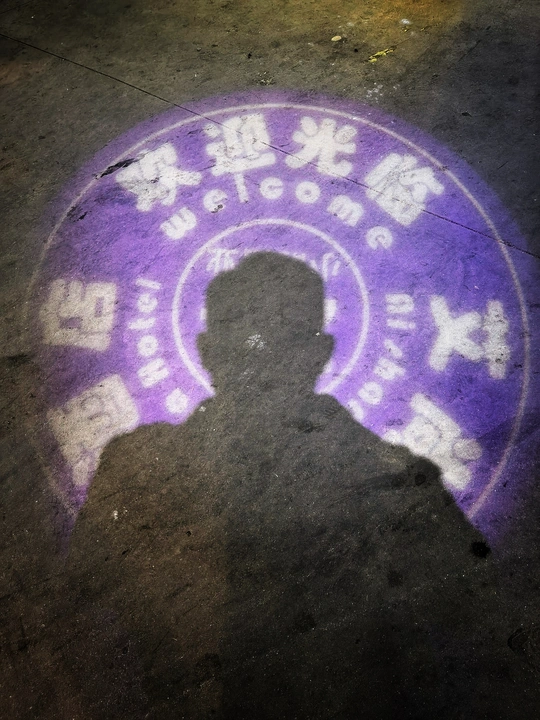 人行道上有一个紫色灯光下的影子