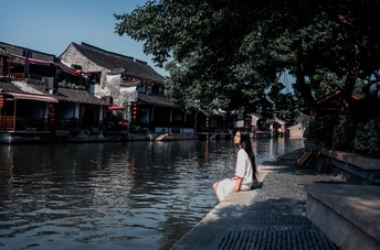 一个拿着冲浪板的女人站在运河的水中