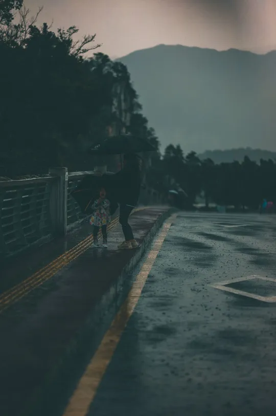 雨中的街道 一个人拿着雨伞 一个人骑着滑板站在路边