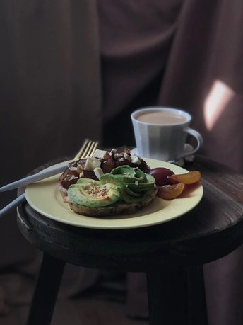 桌子上放着一小盘食物 旁边是一杯咖啡和一把刀叉