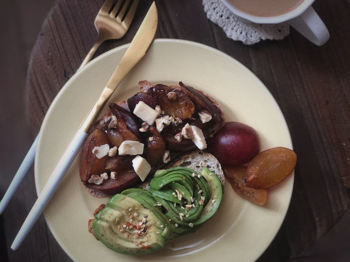 桌子上的一盘白色食物 里面有一杯茶、叉子、沙拉和一些肉和蔬菜