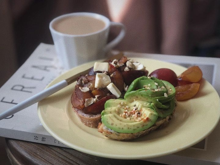 桌子上放着一盘黄色的食物 旁边是一杯咖啡和烤面包