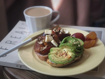 桌子上放着一盘黄色的食物 旁边是一杯咖啡和烤面包