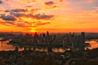 城市上空的日落 前景是一条河 背景是天际线