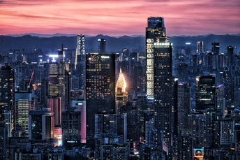 一张在日落时分拍摄的城市夜晚的照片 前景是香港和其他摩天大楼的天际线