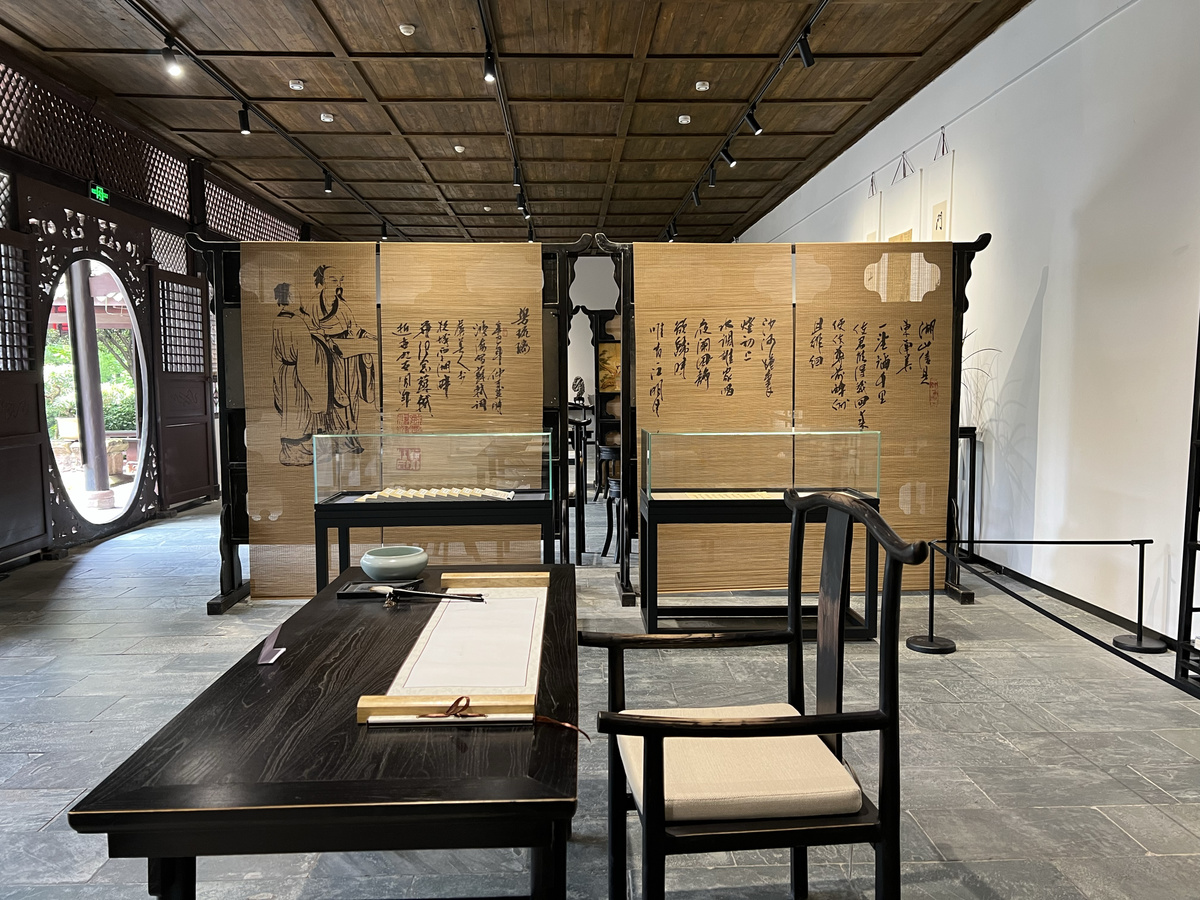 一个大房间 里面有木制的桌子、椅子和长凳 墙上写着亚洲文字