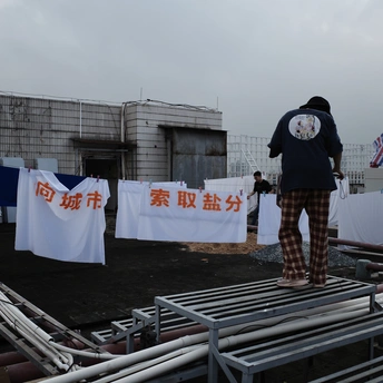 站在一栋楼前挂着旗帜的绳子上的一个男人