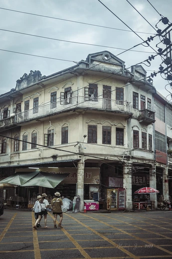 人们穿过一条靠近一座老建筑的街道