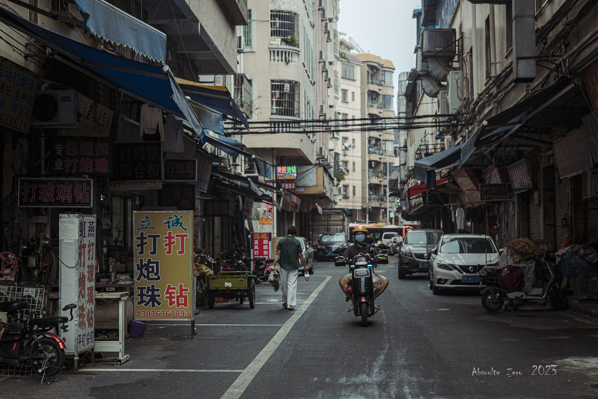 一条亚洲城市的狭窄街道 人们骑摩托车和汽车。
