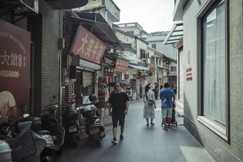 人们走在一条被商店环绕的狭窄小巷中