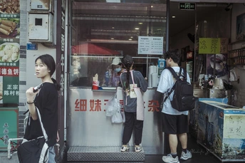 一些年轻女性站在街上的一家商店前。