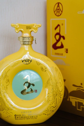 一个黄色的花瓶坐在一个黄色的盒子旁边